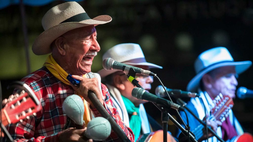 Una agrupaci&oacute;n musical interpretando m&uacute;sica parrandera en Bello, Antioquia, revive las ra&iacute;ces campesinas y caribe&ntilde;as de la regi&oacute;n. Con instrumentos tradicionales, crean un ambiente festivo que celebra la identidad y tradici&oacute;n paisa.