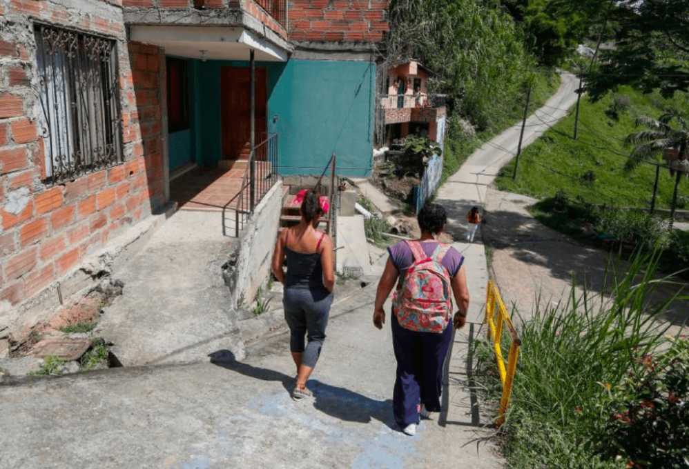 Habitantes de un barrio de Medellín caminando por sus calles.