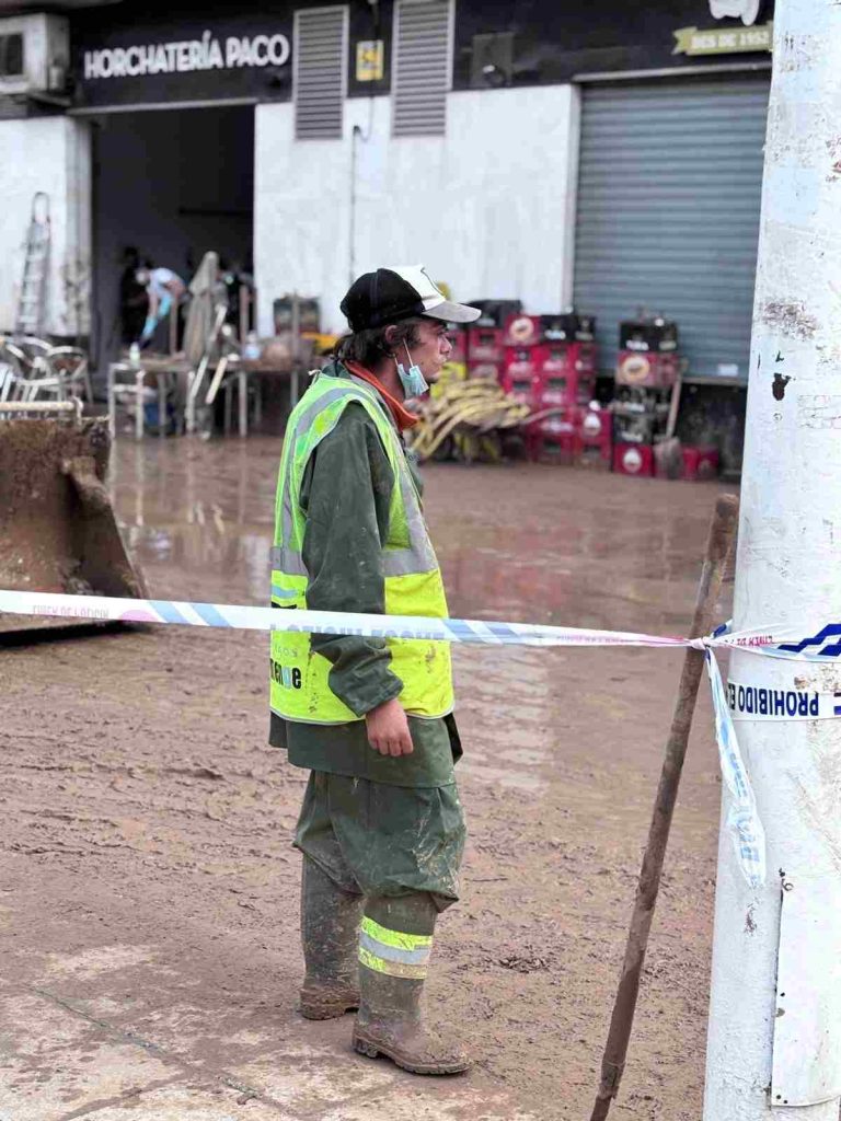Miembros de un equipo de emergencia colaboran en la Comunidad Valenciana para ayudar a los habitantes a remover el lodo y el agua acumulada tras el paso de la DANA en España