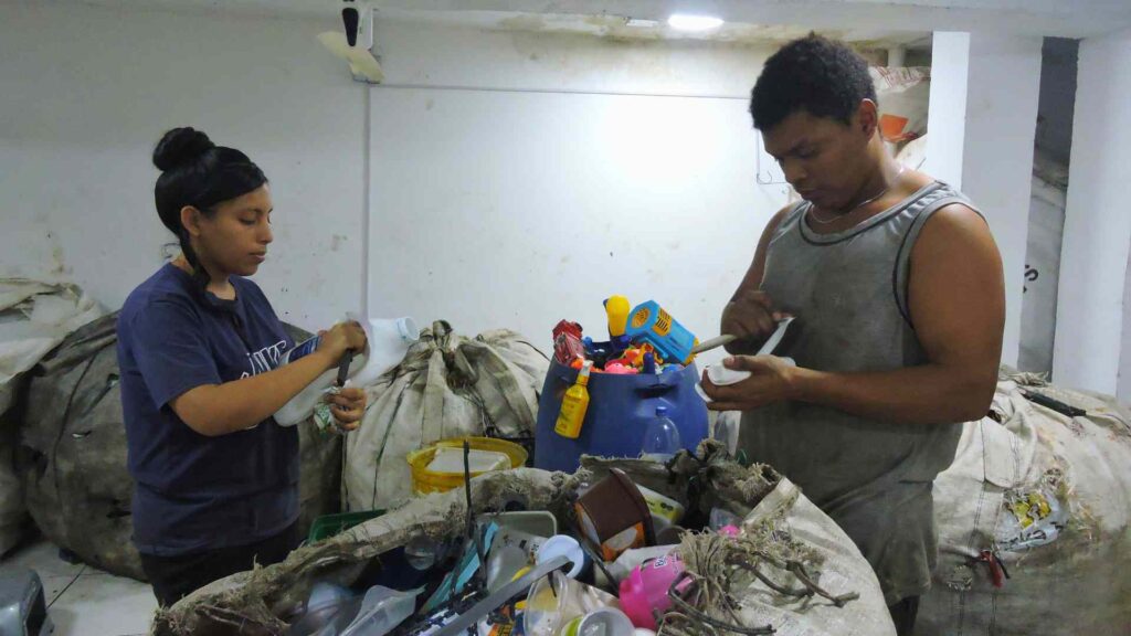 Fotografía de dos recicladores en Medellín separando materiales reciclables